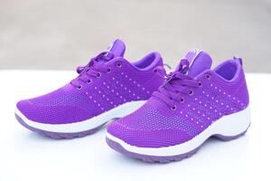 Pair of new purple sneakers. Fashionable and comfortable sport footwears. outdoor background.  Concept, shoes for doing sport or exercise also can wear for traveling, hiking. photo