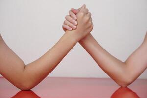 Close up two hands clasped arm wrestling. Concept, strength comparison competition. Strong body strengthen challenge recreation activity for competitive fun game. photo