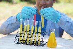 Colorful chemical substance in test tubes that chemist is mixing outdoor.Concept, outdoor teaching and learning. science subject,Project work. Experiment, education, learning by doing approach. photo