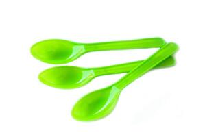 Green plastic disposable spoons isolated on white background. Concept, equipment for eating utensil, can be reuse or recycle to made DIY craft. photo