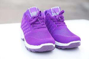 Pair of new purple sneakers. Fashionable and comfortable sport footwears. outdoor background.  Concept, shoes for doing sport or exercise also can wear for traveling, hiking. photo