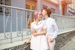 Two hugging girls near the fence in the city photo