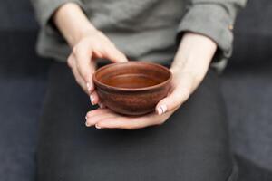 Woman offers hot tea in a vintage ceramic cup. photo