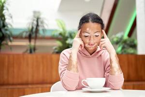 Black african american woman with vitiligo pigmentation skin problem indoor dressed pink hoodie photo