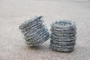 Two rolls of metal barbed wire. Concept, construction tool. Barbed wire is used for make fences , secure property ,make border to show the territory of area. photo