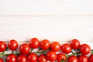 Cereza Tomates en el blanco de madera mesa foto