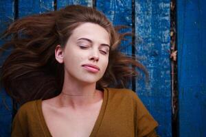 Beautiful caucasian young woman Lying on her back on wooden background. photo