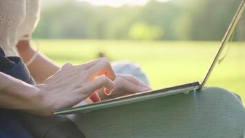 fechar acima fêmea mãos digitando em teclado enquanto computador portátil computador em a colo, controlo remoto trabalhando lugar, Cálculo resolução fixação problema, planejamento escrevendo papéis para final exame, trabalhando mãos com luz solar video