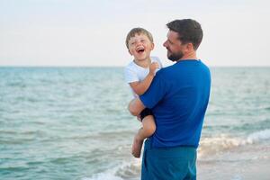 Father son spending time together sea vacation Young dad child little boy walking beach photo