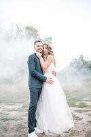 novia y novio a Boda día caminando al aire libre en verano naturaleza. nupcial pareja, contento recién casado mujer y hombre abrazando en verde parque. amoroso Boda Pareja exterior. novia y novio foto