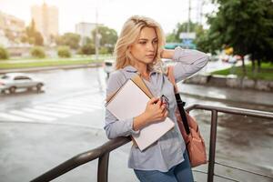 Enthusiastic Serious beautiful young girl holding pile of books standing near campus lifestyle positivity academic graduating university school photo