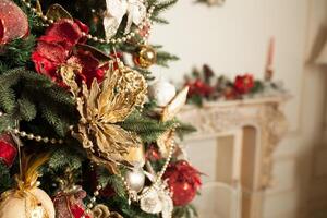 cerca arriba de decoración rojo y oro decorado en verde Navidad árbol o pino con desenfocado borroso fundamento foto