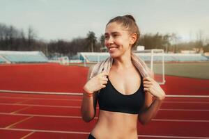 A confident girl woman with a towel around his neck after a hard practice looks ready for more. photo