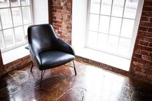 chair stands near a window on the brick wall background in the windows photo