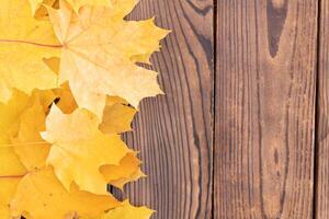 Autumn leaves frame on wooden background top view Fall Border yellow and Orange Leaves vintage wood table Copy space for text. photo