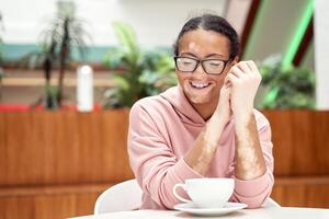 Black african american woman with vitiligo pigmentation skin problem indoor dressed pink hoodie photo