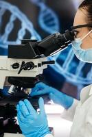 Medical Research Scientist Looks at Biological Samples Under Digital Microscope in Applied Science Laboratory. Beautiful Caucasian Lab Engineer in White Coat Working on Vaccine and Medicine photo