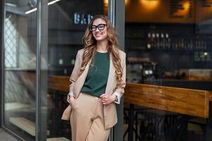 negocio mujer restaurante propietario vestido elegante traje pantalón en pie cerca restaurante grande ventana foto