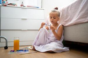 pequeño niña hacer cerámico decoración sentado piso foto