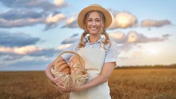 Female farmer standing wheat agricultural field Woman baker holding wicker basket bread product photo