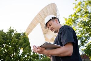 Engineer looking earth based astronomical radio telescope photo