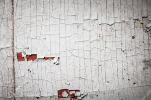 Cracked wall with old layers of paint in abandoned house photo