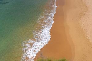 Aerial view of sea waves and sandy beach photo