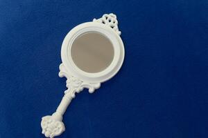 Vintage style white women hand mirror with decoration, women gadget, beauty concept photo