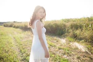 Beautiful caucasian girl walking on the field. Summer time day photo