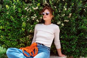 Young woman in light summer clothes with a reusable mesh eco bag photo