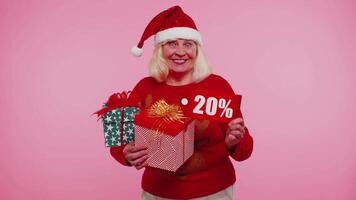 Grandmother in Christmas sweater showing gift box and 20 Percent discount inscriptions banner text video
