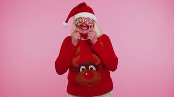 nonna nel Natale maglione Tenere caramella a strisce Lecca-lecca nascondiglio dietro a loro Ingannare in giro video