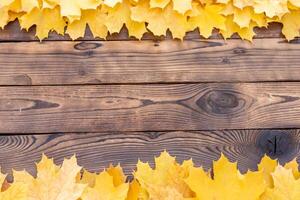 Autumn leaves frame on wooden background top view Fall Border yellow and Orange Leaves vintage wood table Copy space for text. photo