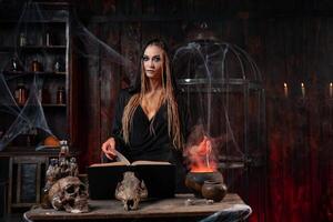 Halloween, witch use magic book and cauldron prepare poison or love potion photo