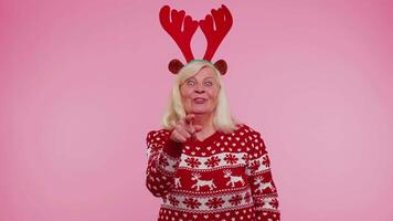 senior jul mormor kvinna leende upprymd pekande till kamera skönhet välja tur- vinnare video
