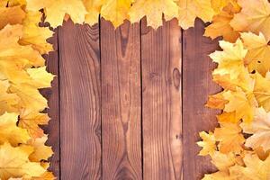 Autumn leaves frame on wooden background top view photo