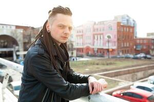 rocker rock star young man walking on the city street autumn day photo