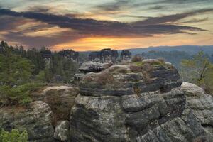 Rugged rocks on the Basteibridge. Wide view over trees and mountains. National park photo