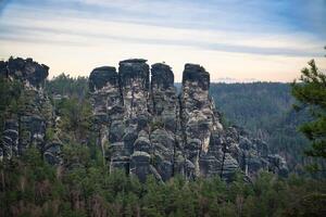 escabroso rocas en el puente bastei. amplio ver terminado arboles y montañas. nacional parque foto