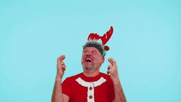 Cheerful man in t-shirt Santa Christmas hat getting present gift box, expressing amazement happiness video
