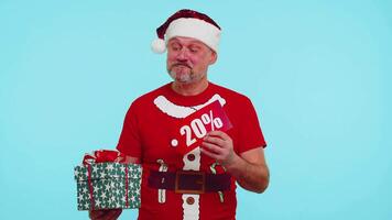 Mens in rood Kerstmis t-shirt tonen geschenk doos en 20 procent korting inscripties banier tekst Notitie video