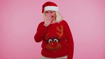 Grandmother woman in Christmas sweater with deers waves hand palm in hello gesture welcomes someone video