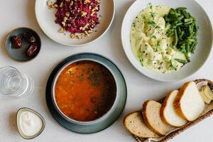 Ramadan food preparation for iftar meal during the holy month. Glass of water and bowl of dates. Soup, curry hicken and beets salad photo