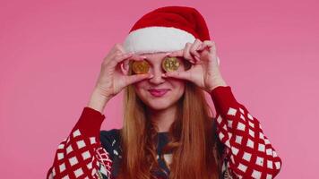 ragazza nel Natale maglione mostrando d'oro bitcoin BTC criptovaluta i soldi investimento, estrazione futuro video