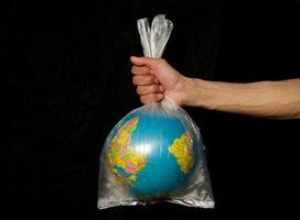 tierra envuelto arriba en el plastico bolsa. globo en un el plastico bolsa. concepto de el plastico contaminación de el tierra. mundo ambiente día concepto. foto