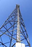 Antena eléctrica y torre transmisora de comunicaciones en un paisaje del norte de Europa contra un cielo azul foto