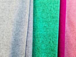 Detailed close up view on samples of cloth and fabrics in different colors found at a fabrics market photo