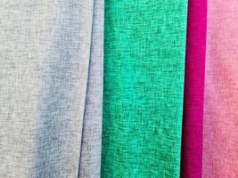 Detailed close up view on samples of cloth and fabrics in different colors found at a fabrics market photo