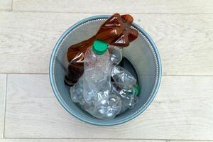 Five different plastic bottles in the office trash can. Ecology and recycling of waste from various raw materials photo