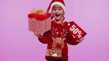 kind meisje in Kerstmis hoed tonen geschenk doos en 50 procent korting inscripties banier tekst Notitie video